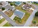 Aerial view of the home featuring manicured landscaping, a gray roof, a brick paver drive, and mature palm trees at 9750 Se 179Th Pl, Summerfield, FL 34491