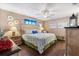 Serene main bedroom with wood floors, a ceiling fan, and nautical-themed decor creating a tranquil retreat at 9750 Se 179Th Pl, Summerfield, FL 34491