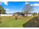 Large backyard featuring a screened-in pool, patio, and a vintage metal barrel at 10100 Se 69Th Ave, Belleview, FL 34420