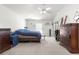 Spacious bedroom with neutral carpet, vaulted ceiling, ceiling fan, dresser and a sliding door to the lanai at 10100 Se 69Th Ave, Belleview, FL 34420