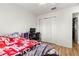 Bedroom featuring wood floors, a ceiling fan, and a double-door closet for ample storage at 10100 Se 69Th Ave, Belleview, FL 34420