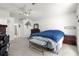 Bedroom featuring neutral carpet, ceiling fan, and a bench at the foot of the bed at 10100 Se 69Th Ave, Belleview, FL 34420