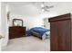 Bedroom featuring carpet, ceiling fan and a dark wood dresser at 10100 Se 69Th Ave, Belleview, FL 34420