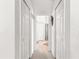 Well-lit hallway featuring multiple closet doors for convenient storage at 10100 Se 69Th Ave, Belleview, FL 34420