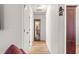 Hallway showcasing wood floors, white walls and doors, and a mirrored curio cabinet at 10100 Se 69Th Ave, Belleview, FL 34420