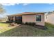 A view of the backyard, featuring a glass sunroom, flowerbeds and well-maintained lawn at 1029 Sw 157Th Ln, Ocala, FL 34473