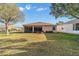 Wide backyard view featuring a glass sunroom, flowerbeds, and well-maintained lawn at 1029 Sw 157Th Ln, Ocala, FL 34473