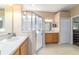 Bathroom featuring dual sinks, a shower with glass doors and neutral tile floors at 1029 Sw 157Th Ln, Ocala, FL 34473