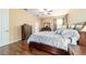 Bedroom with wood floors featuring a ceiling fan, large bed and natural lighting at 1029 Sw 157Th Ln, Ocala, FL 34473