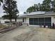 Home exterior featuring solar panels and a two-car garage with a screen door at 11 Pecan Pass Loop, Ocala, FL 34472