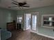 This living room has light-green walls, a ceiling fan, and glass-panel doors to a sunroom at 11 Pecan Pass Loop, Ocala, FL 34472