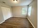 Neutral bedroom featuring laminate floors, a large closet, and a bright window at 11484 Sw 76Th Cir, Ocala, FL 34476