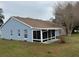 A single-story home with a screened in porch and blue siding and a well-manicured lawn at 11484 Sw 76Th Cir, Ocala, FL 34476