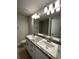 Bathroom featuring double sinks with granite countertop, modern lighting, and tile flooring at 13418 Sw 60Th Court Rd, Ocala, FL 34473