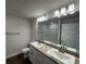 Bathroom featuring double sinks with granite countertop, modern lighting, and wood-look flooring at 13418 Sw 60Th Court Rd, Ocala, FL 34473