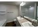 Bathroom featuring double sinks with granite countertop, modern lighting, and wood-look flooring at 13418 Sw 60Th Court Rd, Ocala, FL 34473