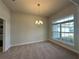 Bright, airy dining room featuring carpet, a chandelier, and large window for natural light at 13418 Sw 60Th Court Rd, Ocala, FL 34473