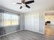 Bedroom with wood-look floors, a ceiling fan, and a spacious closet at 13800 Se 80Th Ave, Summerfield, FL 34491