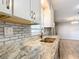 Close-up of an updated kitchen's granite countertop with stainless steel sink and white subway tile backsplash at 13800 Se 80Th Ave, Summerfield, FL 34491