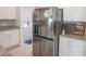 Stainless steel refrigerator, granite countertops, and white cabinets in modern kitchen at 1482 Ne 160Th Pl, Citra, FL 32113