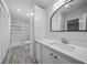 Bathroom featuring marble shower, quartz counters, built-in cabinet, mirror, and blinds at 1541 Hillcrest Dr, Lady Lake, FL 32159