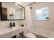 Modern bathroom featuring a tiled tub/shower combo, floating sink, and vanity mirror at 1655 Sunnyside Dr, Maitland, FL 32751