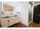 Bright bathroom featuring an illuminated mirror, double sinks, and a glass-enclosed shower at 1655 Sunnyside Dr, Maitland, FL 32751