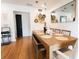 Dining area with wood floors, table, seating, black door, and decorative wall hangings at 1655 Sunnyside Dr, Maitland, FL 32751