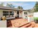 Inviting front porch with brick tile, complemented by white walls, windows, and decorative planters at 1655 Sunnyside Dr, Maitland, FL 32751