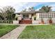 Charming single-story home with beautiful landscaping, a stone walkway, and red brick stairs at 1655 Sunnyside Dr, Maitland, FL 32751