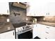 Close-up of a modern kitchen with stainless steel range and pot filler above a dark subway tile backsplash at 1655 Sunnyside Dr, Maitland, FL 32751