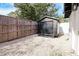 Backyard featuring a storage shed, surrounded by a wooden fence and light colored stone ground cover at 1655 Sunnyside Dr, Maitland, FL 32751