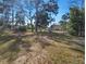 View of the spacious backyard, grass lawn, and mature trees at 18 Juniper Pass Crse, Ocala, FL 34480