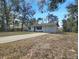 A cozy single-story home with a driveway nestled among lush trees and foliage at 18 Juniper Pass Crse, Ocala, FL 34480