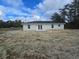 The house has a plain white exterior and double doors in back at 19 Bay Court Pass, Ocklawaha, FL 32179