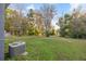 View of the grassy backyard, with lush trees and an air conditioning unit at 21055 Highway 441 N, Micanopy, FL 32667