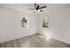 Bright bedroom featuring wood-look flooring, ceiling fan, and white walls for a clean aesthetic at 21055 Highway 441 N, Micanopy, FL 32667