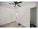 Clean bedroom with wood-look floors, a ceiling fan, and a view into an adjoining room at 21055 Highway 441 N, Micanopy, FL 32667