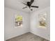 Bright bedroom with wood-look flooring, a ceiling fan, and two windows at 21055 Highway 441 N, Micanopy, FL 32667