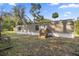 View of a single Gathering home featuring a tan exterior with matching front steps and a large yard at 21055 Highway 441 N, Micanopy, FL 32667