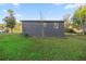 The back of the gray home with a small yard is shown at 21055 Highway 441 N, Micanopy, FL 32667