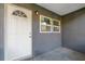 Close up of the front door with house number and grey painted wall at 21055 Highway 441 N, Micanopy, FL 32667