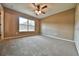 An empty bedroom with carpet, ceiling fan, large window, and neutral paint at 23293 Nw Mallard Ave, Dunnellon, FL 34431