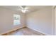 This is a bedroom with light wood floor, a ceiling fan, and a window at 24150 Nw Banyan Ln, Dunnellon, FL 34431