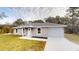 Charming single-story home featuring a garage, modern windows, and well-maintained landscaping at 24150 Nw Banyan Ln, Dunnellon, FL 34431