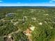 Beautiful aerial shot of the property surrounded by lush trees, with a distant view of a serene lake at 29 Guava Pass, Ocklawaha, FL 32179