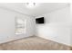 Bright bedroom featuring neutral carpet, a window and a wall mounted TV at 29 Guava Pass, Ocklawaha, FL 32179