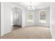 Open concept dining area leading to the entry and featuring a chandelier light fixture and a view to the front yard at 29 Guava Pass, Ocklawaha, FL 32179