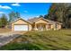 Beautiful one-story home showcasing an attached two-car garage, lovely front lawn, and an arched doorway at 29 Guava Pass, Ocklawaha, FL 32179