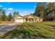 Inviting single-Gathering home featuring a well-maintained lawn, arched entryway, and attached two-car garage at 29 Guava Pass, Ocklawaha, FL 32179